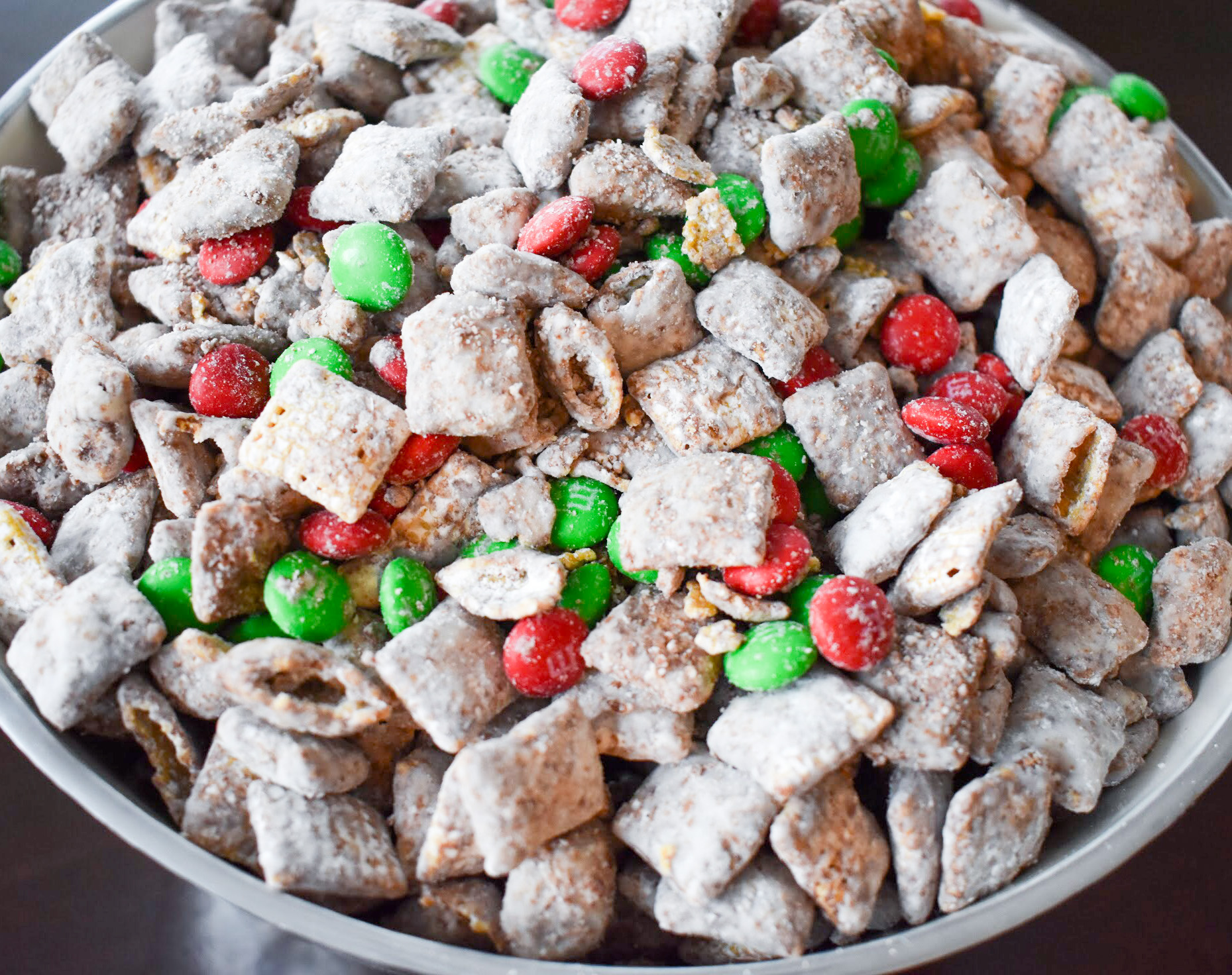 Your family will love this kid-friendly Christmas dessert recipe for Reindeer Treats! It doesn't matter whether you call it Reindeer Treats, Reindeer Chow, Christmas Muddy Buddies, or even Puppy Chow... everyone loves a big bowl of this stuff! This holiday version is even more festive with the addition of red and green candies.