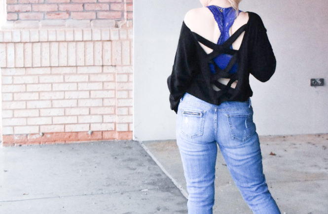 Black Criss-Cross Sweater + Bralette for Large Bust: This black criss-cross sweater styled with ripped jeans and black wedge sneakers is the perfect mix of sporty and sexy for your next date night! Plus, the perfect affordable bralette for large bust ladies. Fashion blogger COVET by tricia shows how to style a perfect date night look mixing black and denim.