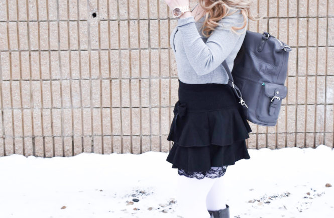 Fashion blogger COVET by tricia styles a ruffled black mini skirt with white tights, a grey bodysuit, grey wedge boots ,and a gorgeous Lily Jade diaper bag. This black mini skirt with ruffles is an affordable statement piece for your wardrobe. Check out this cute winter date night look from Kansas City fashion blogger COVET by tricia.