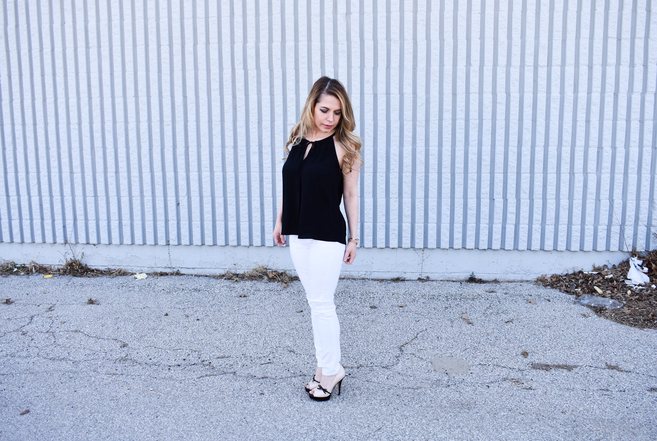 Monochrome Looks for Spring: Some people think you can't wear black and white in the spring. Those people are wrong. Fashion blogger COVET by tricia showcases a springtime monochrome look featuring Banana Republic Stay White Denim and a Tyche black halter top. Minimalist jewelry completes the look. Monochrome is trending for spring 2018, so here's how to effortlessly incorporate it into your wardrobe.