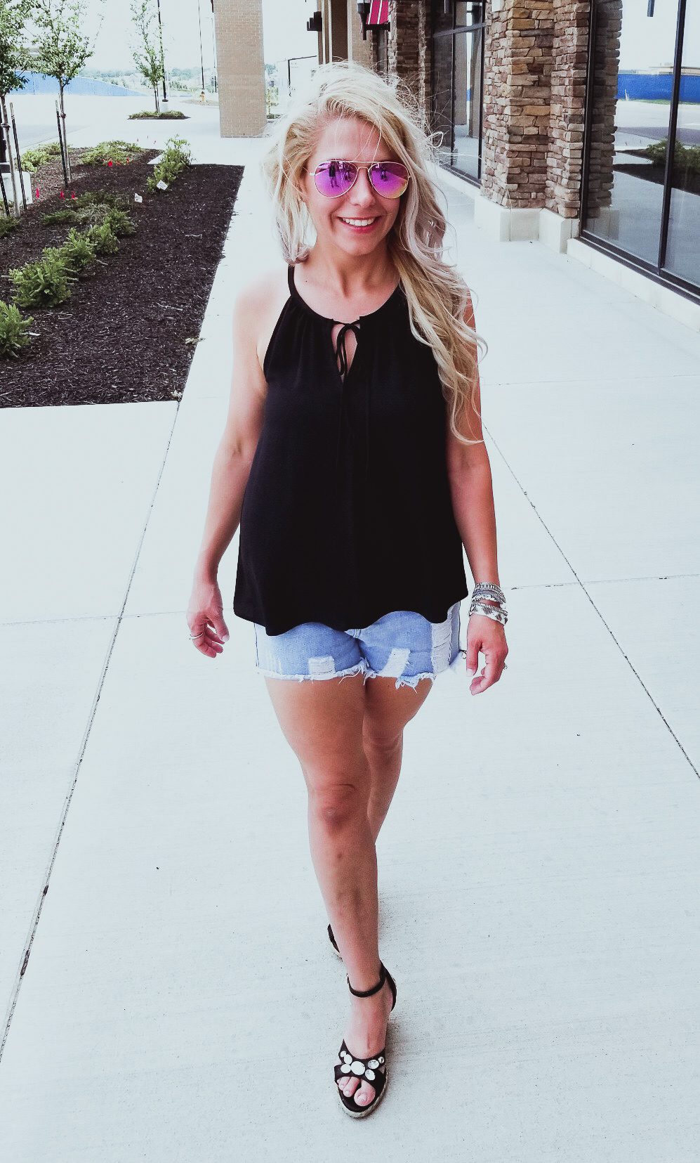 Casual Summer Outfit - Black Halter, Ripped Denim Shorts, and Black Wedges. Summer 2018 is in full swing and here's one of the hottest looks we've seen yet. Pair your ripped jean shorts with a black tank top for a casual summer outfit that's sure to impress. Don't forget the accessories, like the stylish Victoria Emerson bracelet featured here. Click for an exclusive Victoria Emerson coupon code!