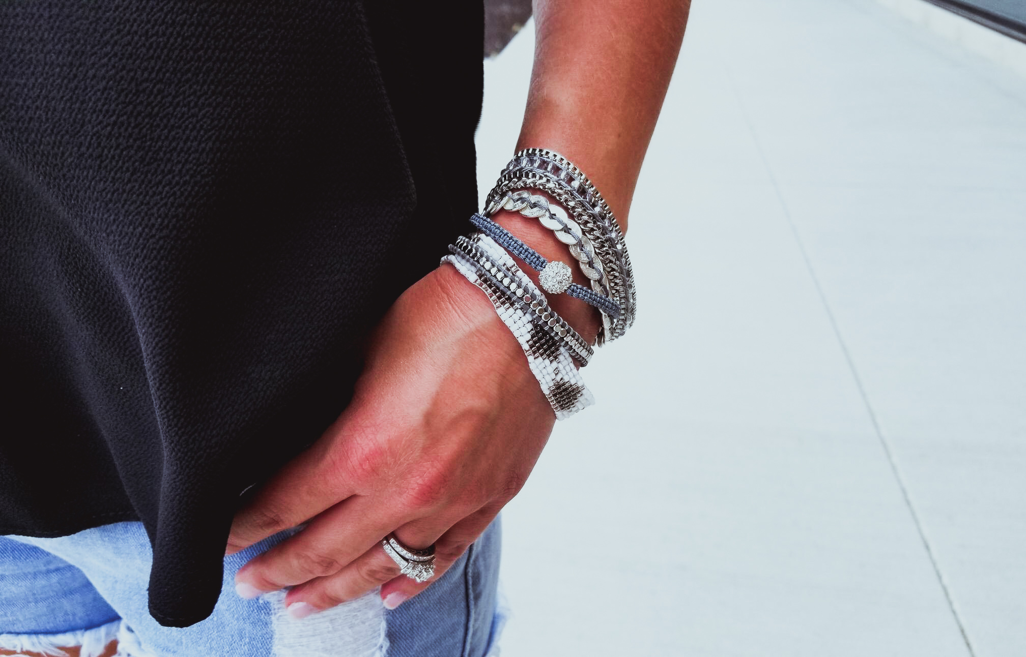 Casual Summer Outfit - Black Halter, Ripped Denim Shorts, and Black Wedges. Summer 2018 is in full swing and here's one of the hottest looks we've seen yet. Pair your ripped jean shorts with a black tank top for a casual summer outfit that's sure to impress. Don't forget the accessories, like the stylish Victoria Emerson bracelet featured here. Click for an exclusive Victoria Emerson coupon code!