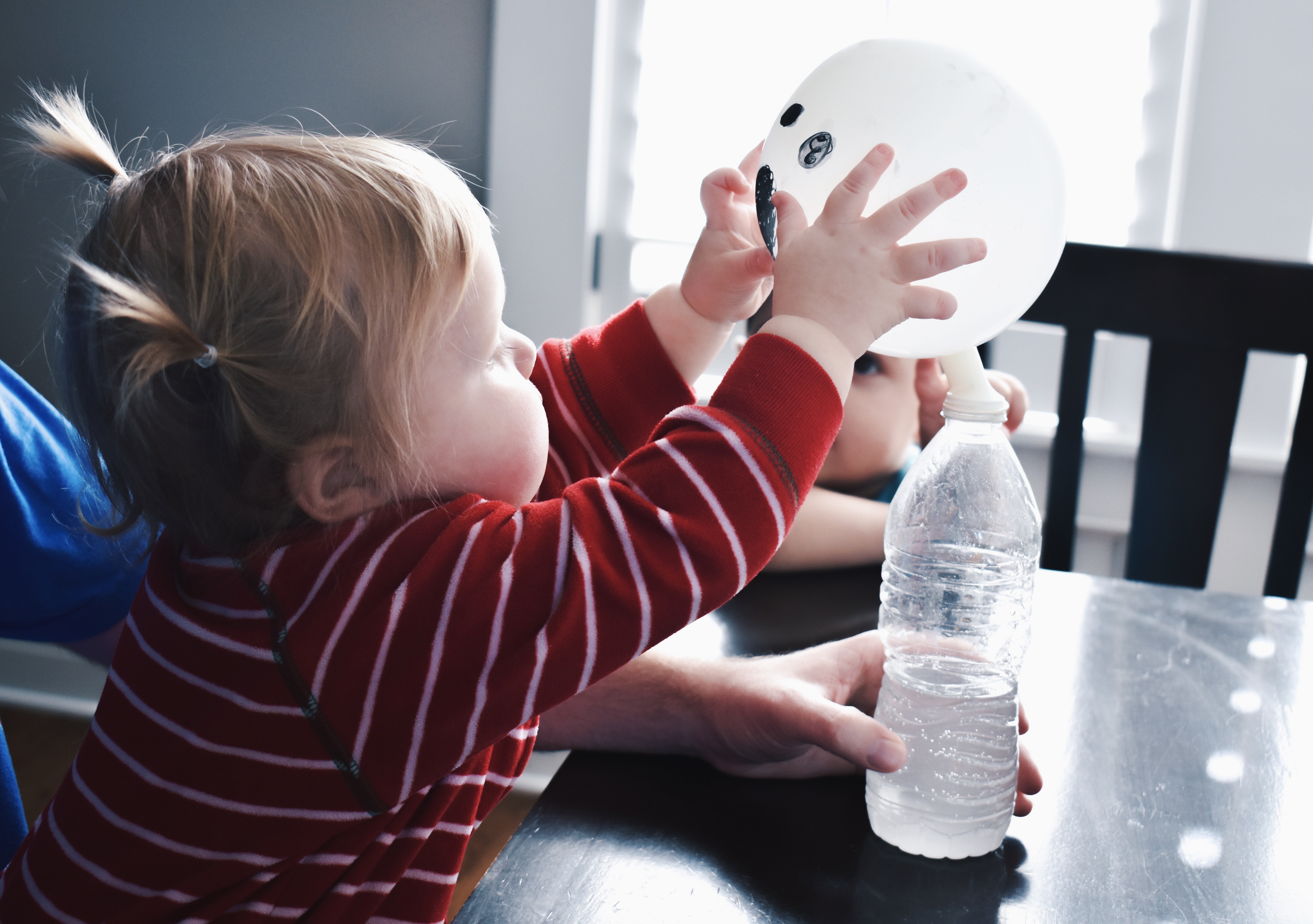 Ghost Balloon Experiment - Halloween Party Activity for Preschoolers - This self-inflating ghost balloon experiment will amaze children and adults alike for your preschool Halloween party! Here's an easy Halloween party activity for preschoolers; all you need is vinegar and baking soda. Try this self-inflating balloon experiment for your next preschool Halloween party! #Halloween #Preschool #STEMLearning