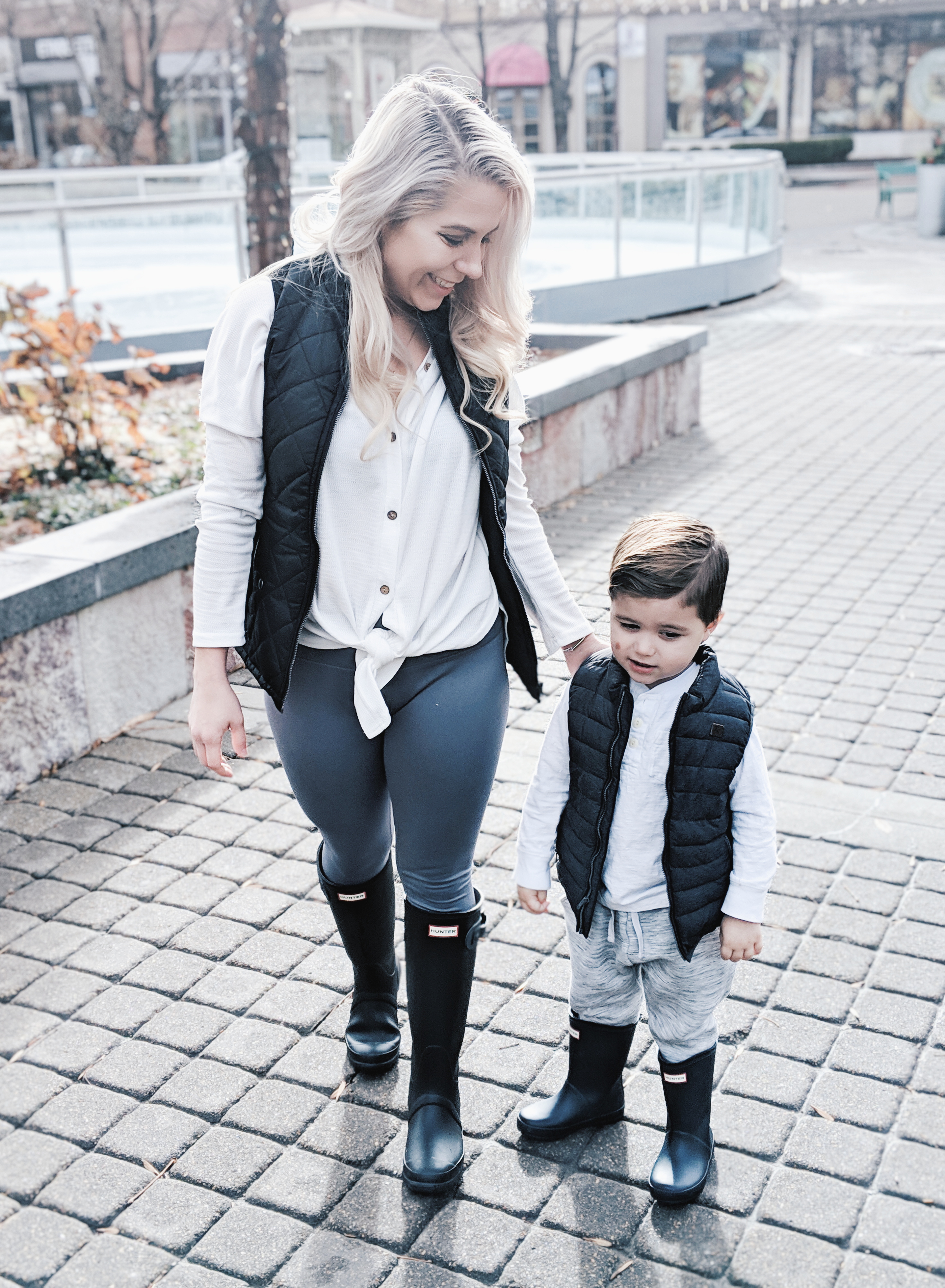 Mommy and Me Outfits - Winter Style: Fashion blogger Tricia Nibarger of COVET by tricia showcases twinning looks for the winter! Find the cutest mommy and me fashion for boy moms or girl moms with these matching puffer vests, henleys, and Hunter boots. Casual winter style for moms. #MommyandMe #MomLife #Twinning