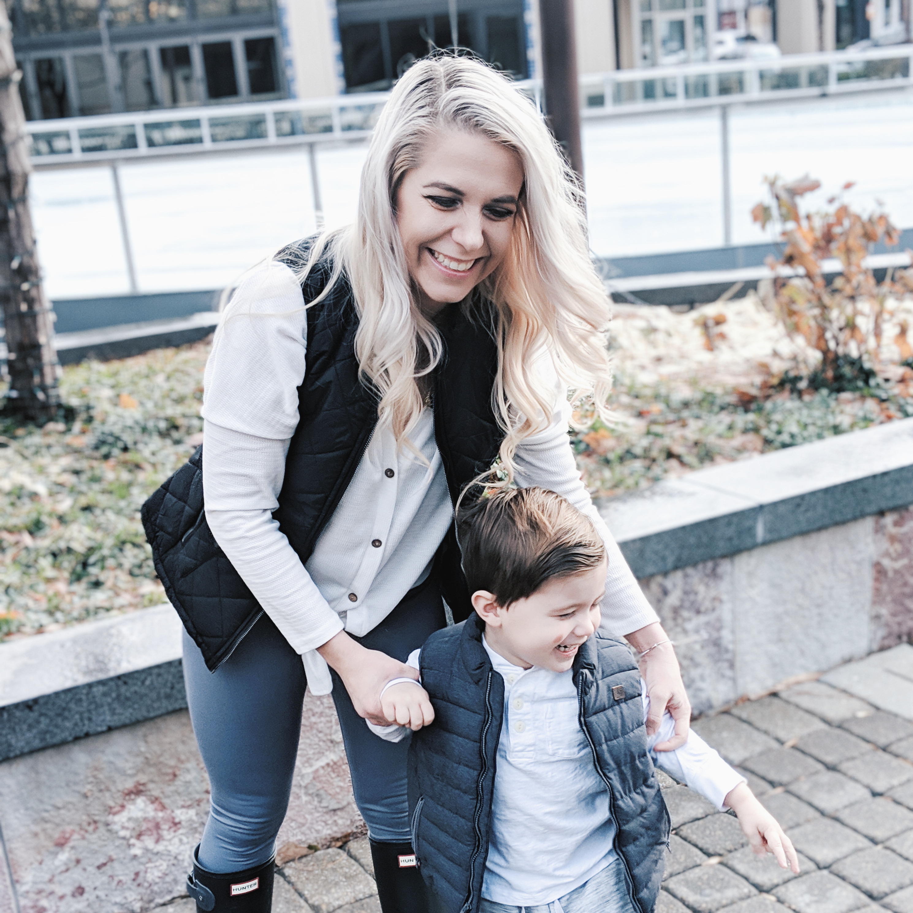 Mommy and Me Outfits - Winter Style: Fashion blogger Tricia Nibarger of COVET by tricia showcases twinning looks for the winter! Find the cutest mommy and me fashion for boy moms or girl moms with these matching puffer vests, henleys, and Hunter boots. Casual winter style for moms. #MommyandMe #MomLife #Twinning