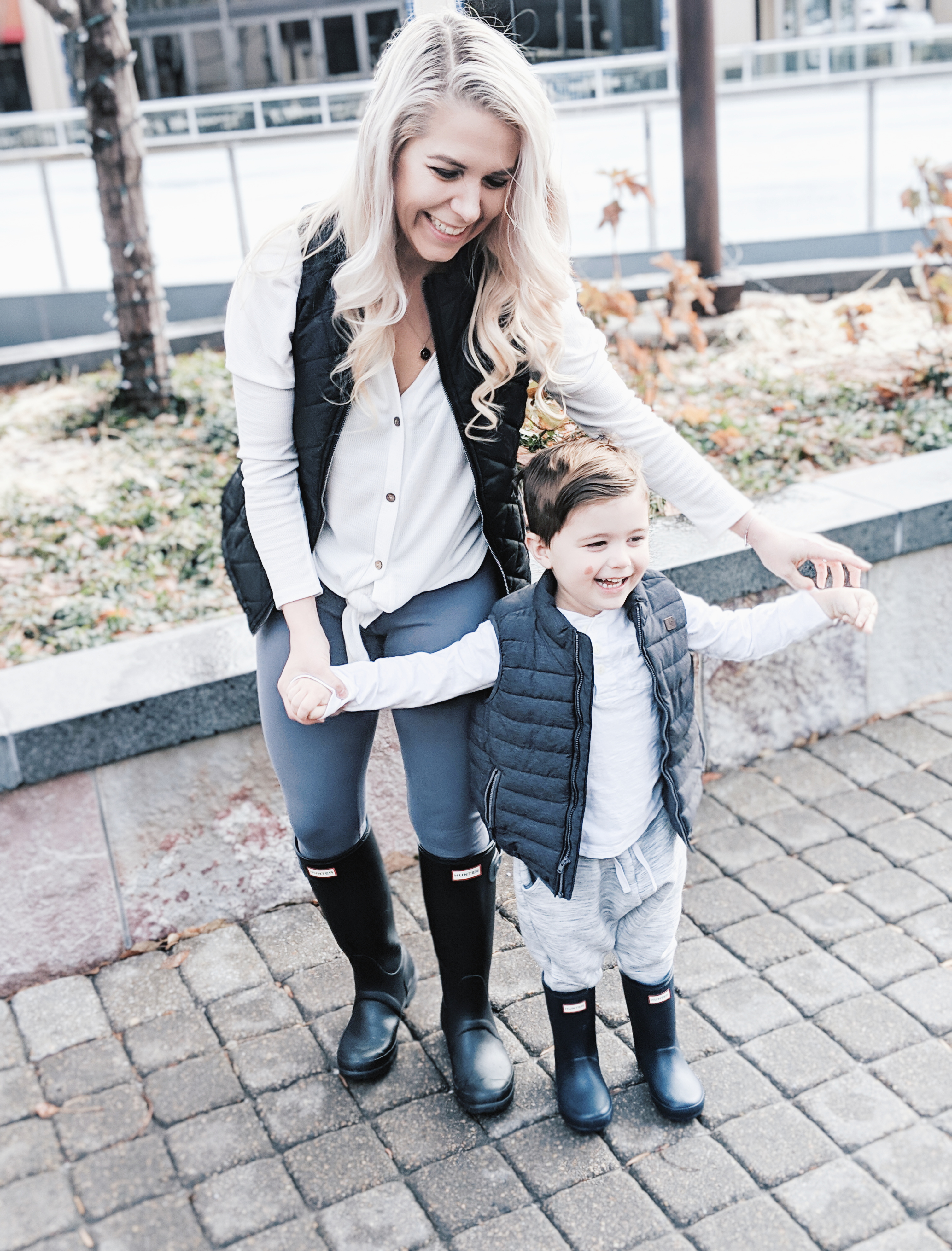 Mommy and Me Outfits - Winter Style: Fashion blogger Tricia Nibarger of COVET by tricia showcases twinning looks for the winter! Find the cutest mommy and me fashion for boy moms or girl moms with these matching puffer vests, henleys, and Hunter boots. Casual winter style for moms. #MommyandMe #MomLife #Twinning