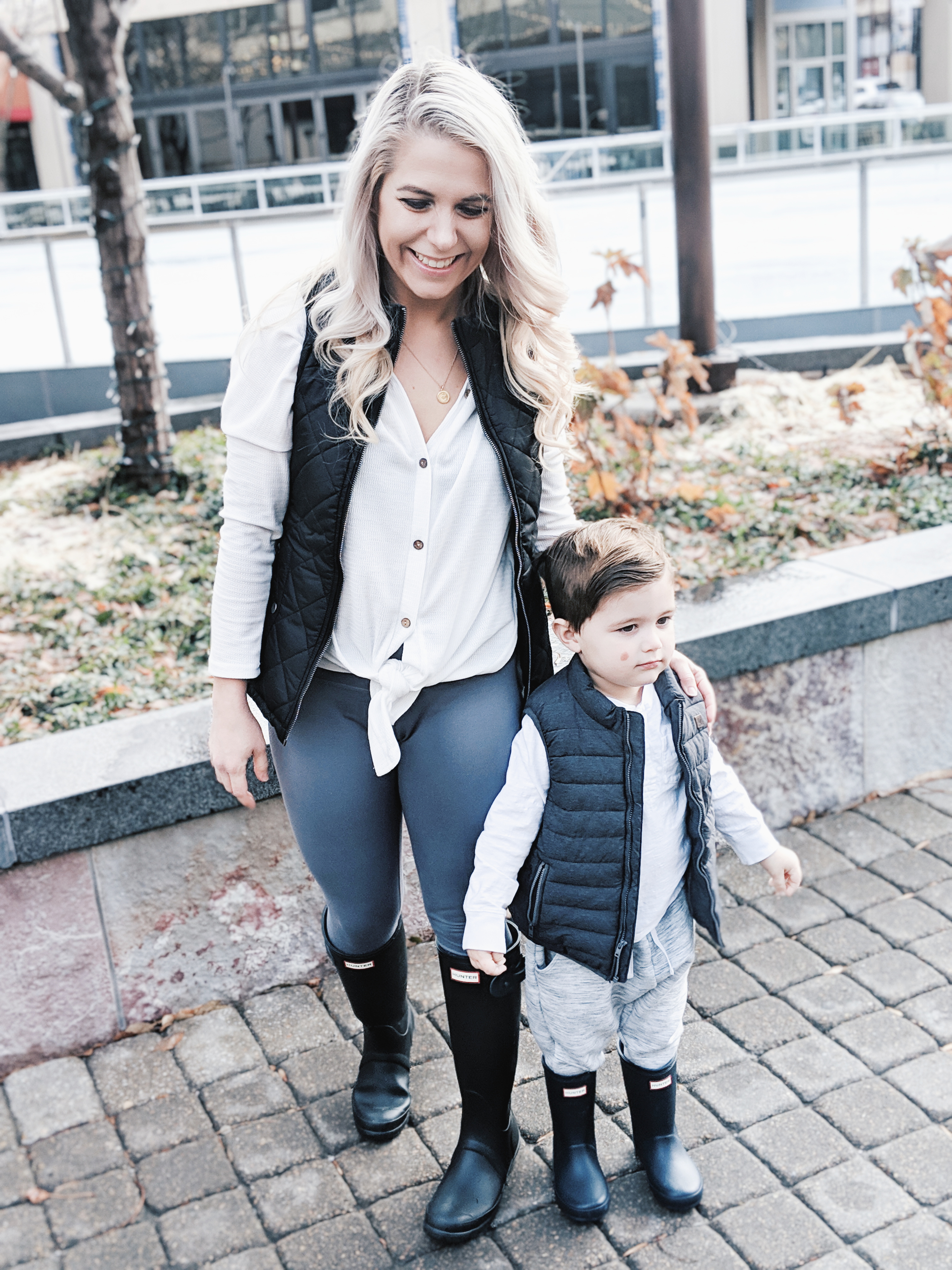 Mommy and Me Outfits - Winter Style: Fashion blogger Tricia Nibarger of COVET by tricia showcases twinning looks for the winter! Find the cutest mommy and me fashion for boy moms or girl moms with these matching puffer vests, henleys, and Hunter boots. Casual winter style for moms. #MommyandMe #MomLife #Twinning