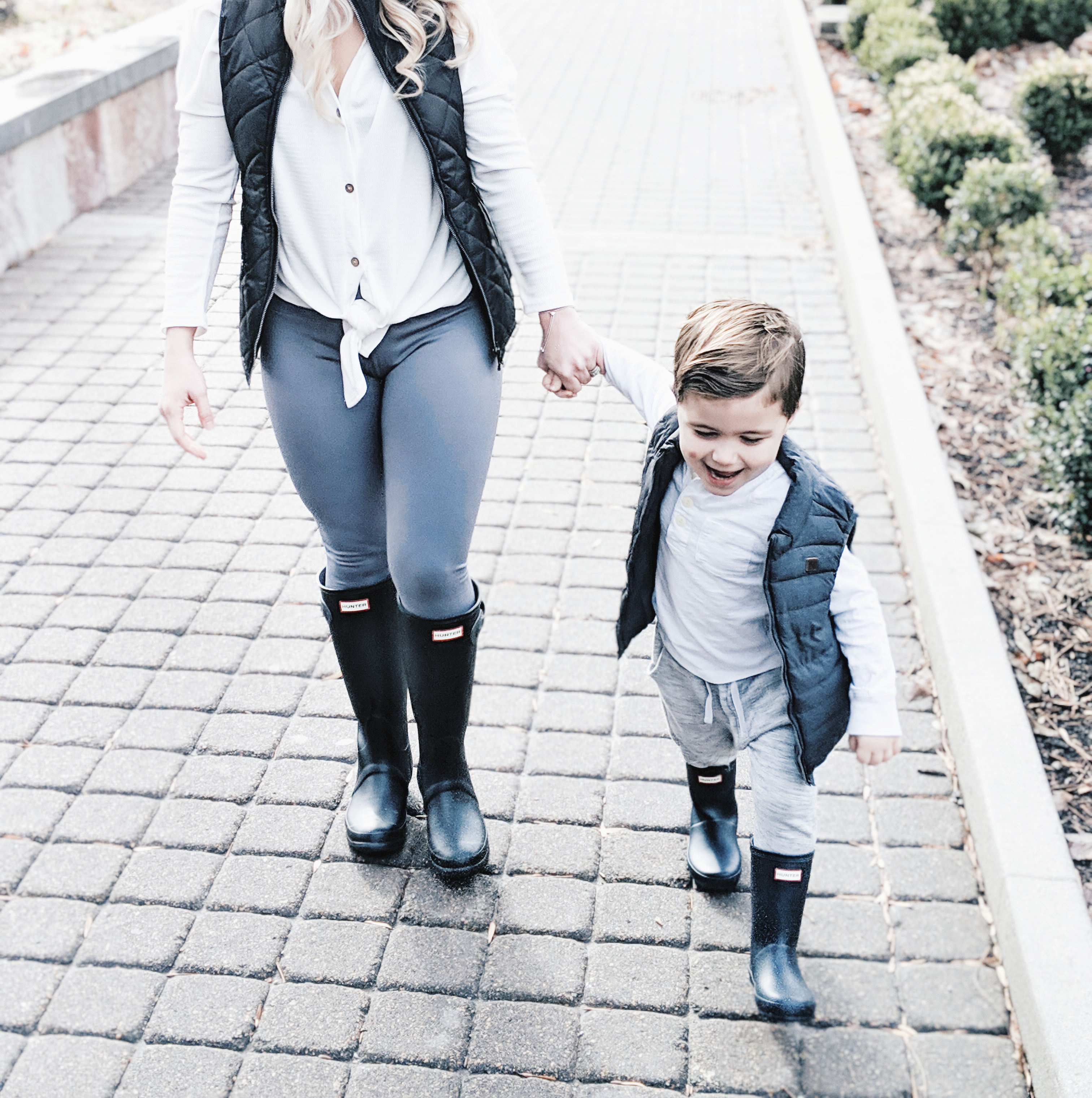 Mommy and Me Outfits - Winter Style: Fashion blogger Tricia Nibarger of COVET by tricia showcases twinning looks for the winter! Find the cutest mommy and me fashion for boy moms or girl moms with these matching puffer vests, henleys, and Hunter boots. Casual winter style for moms. #MommyandMe #MomLife #Twinning