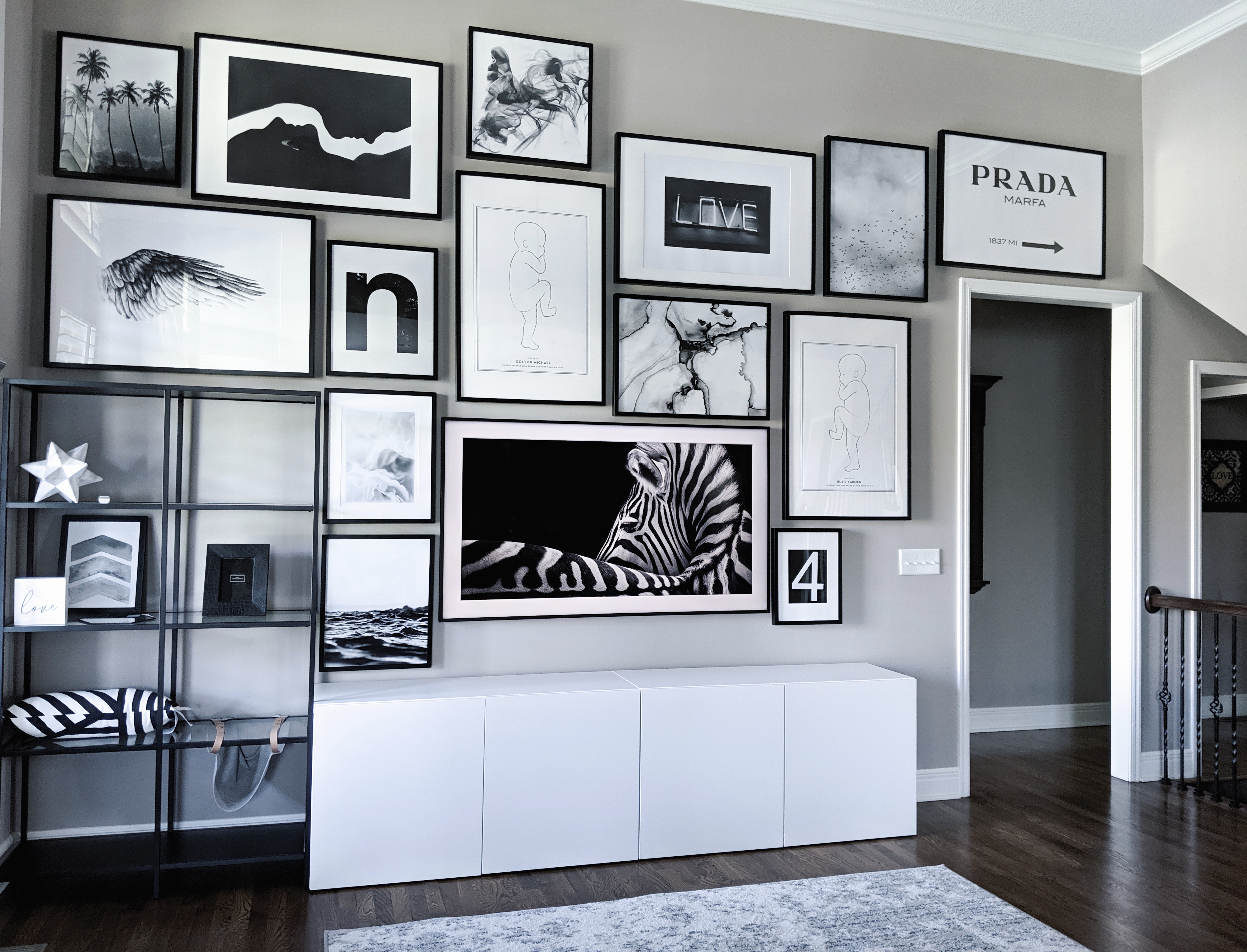 Living Room Gallery Wall Ideas: Looking for gallery wall ideas? This black and white gallery wall is a total showstopper. This is one of the best gallery walls I've ever seen! Includes Desenio posters, Samsung The Frame TV, Ikea Besta as a TV stand, Ikea Ribba frame gallery wall, Ikea Vittsjo shelves. #gallerywall #blackandwhite #monochrome