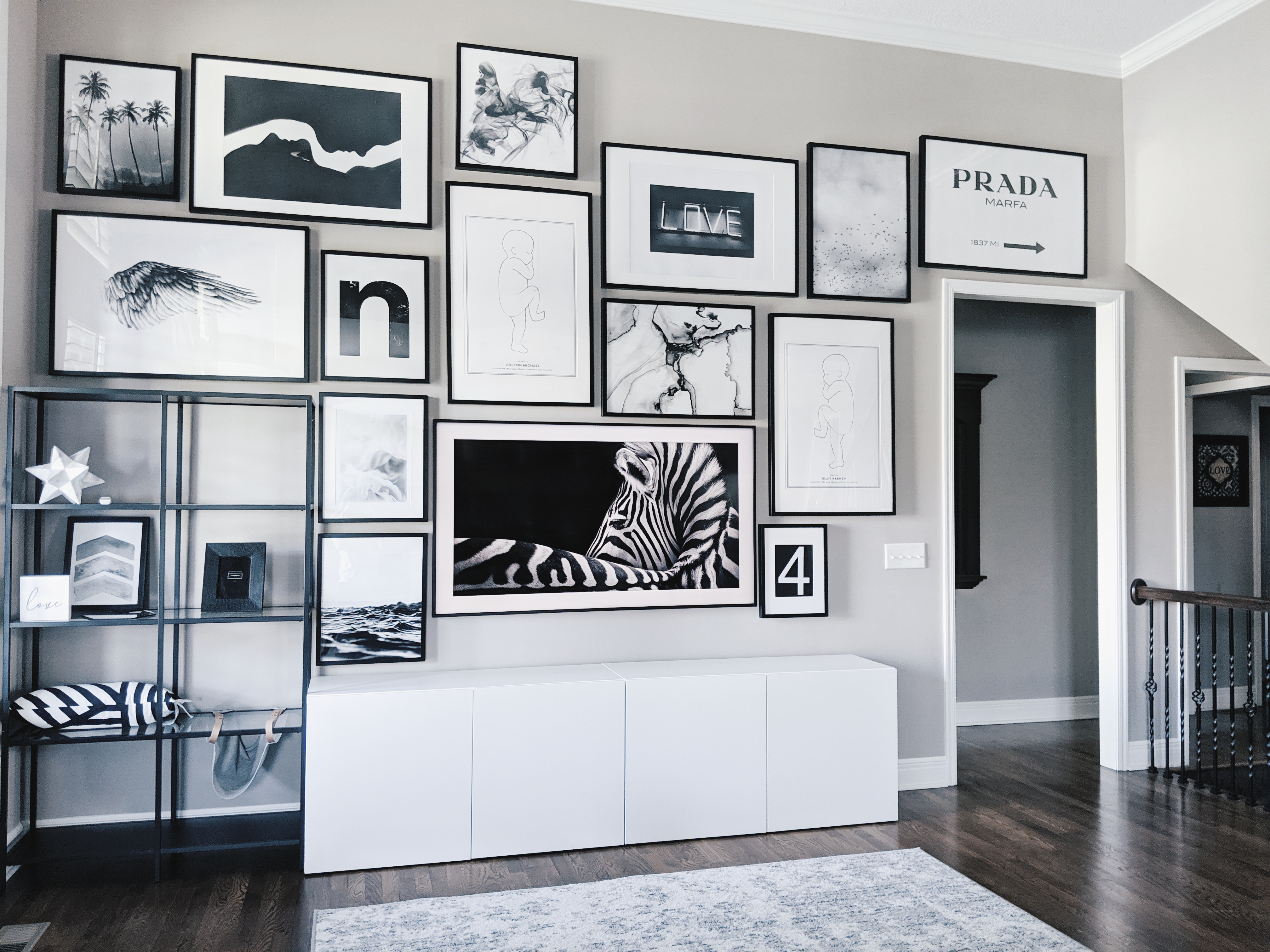 Living Room Gallery Wall Ideas: Looking for gallery wall ideas? This black and white gallery wall is a total showstopper. This is one of the best gallery walls I've ever seen! Includes Desenio posters, Samsung The Frame TV, Ikea Besta as a TV stand, Ikea Ribba frame gallery wall, Ikea Vittsjo shelves. #gallerywall #blackandwhite #monochrome