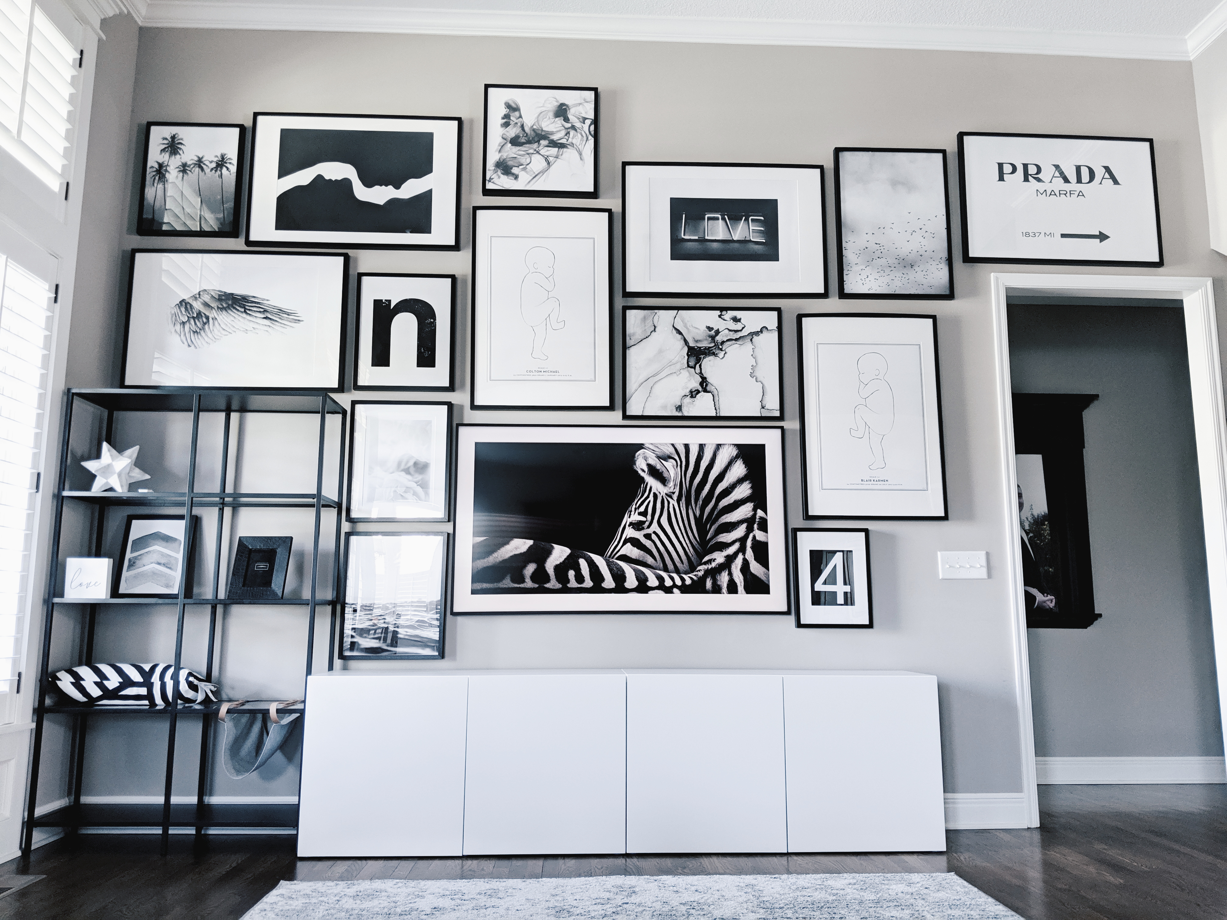 Living Room Gallery Wall Ideas: Looking for gallery wall ideas? This black and white gallery wall is a total showstopper. This is one of the best gallery walls I've ever seen! Includes Desenio posters, Samsung The Frame TV, Ikea Besta as a TV stand, Ikea Ribba frame gallery wall, Ikea Vittsjo shelves. #gallerywall #blackandwhite #monochrome