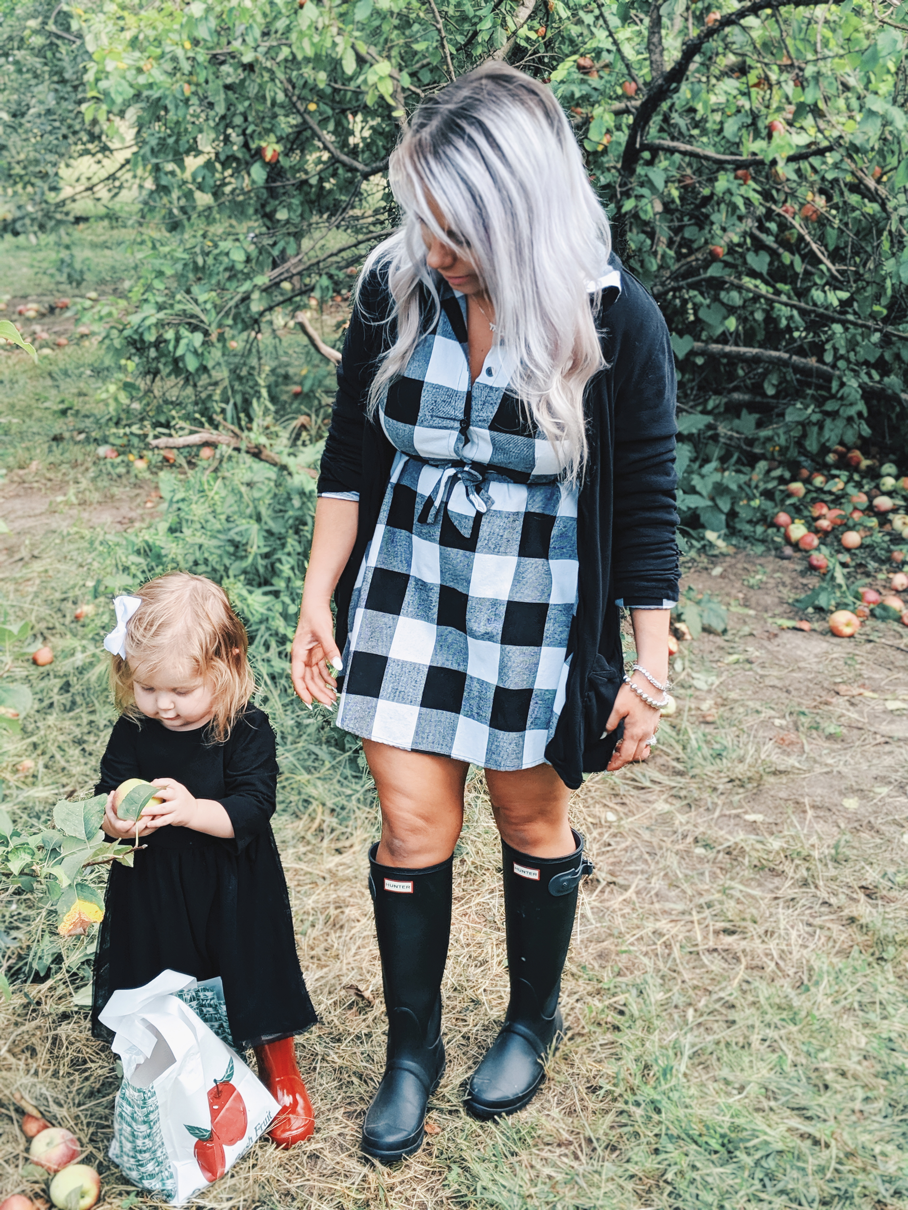 These apple picking photos are too cute! Going apple picking is one of our favorite fall family activities! Here's our apple picking outfits and our experience with apple picking Kansas City at Cider Hill Family Orchard! A great family activity in Kansas City! #applepicking #fallactivities #fall2019 