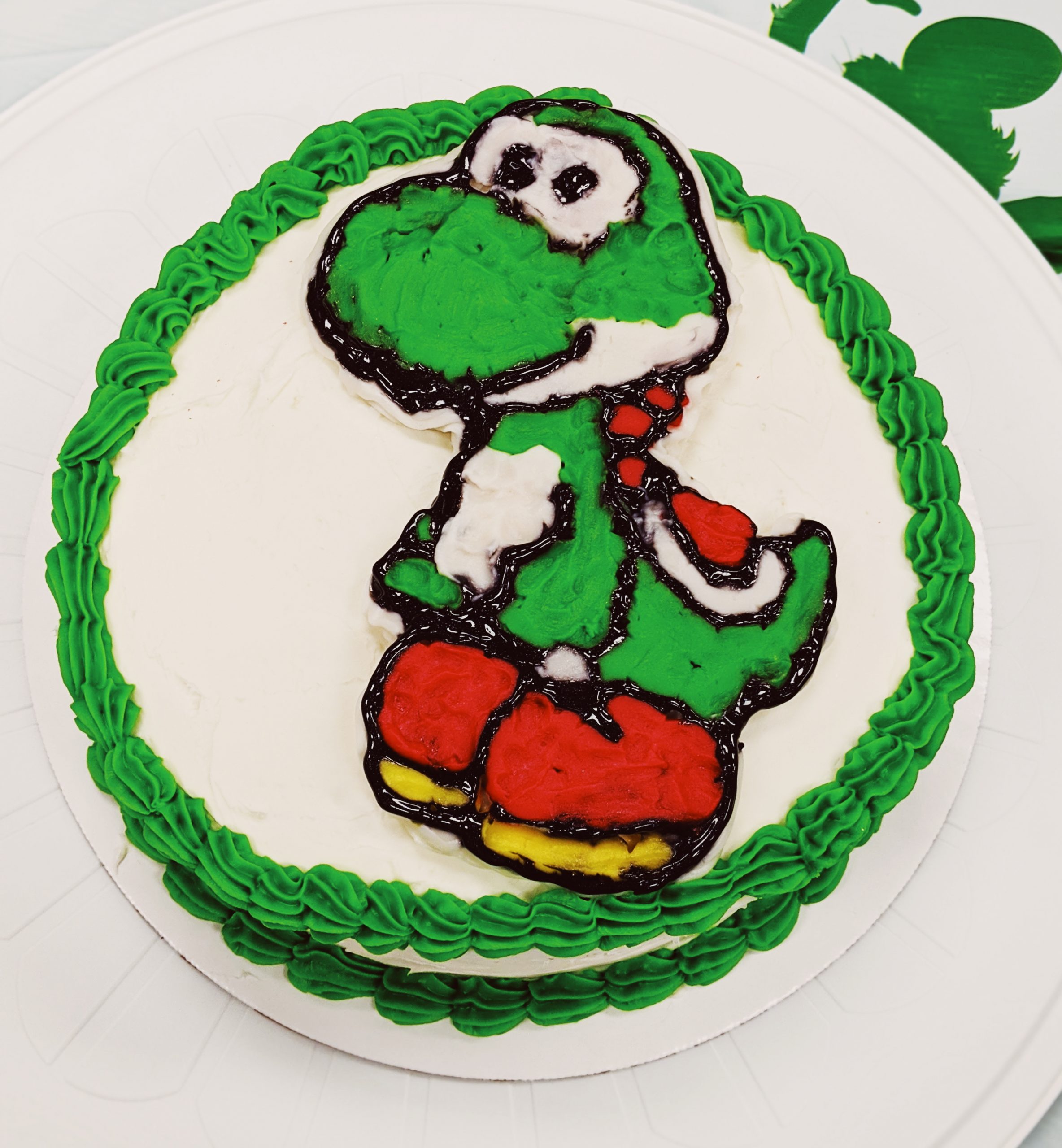 How to Make a Character Cake - DIY Character Cake: Easy DIY Instructions to put ANY character on a cake! Here's how to do a frozen buttercream transfer to make a character cake. #cakedecorating #yoshi #cakes 